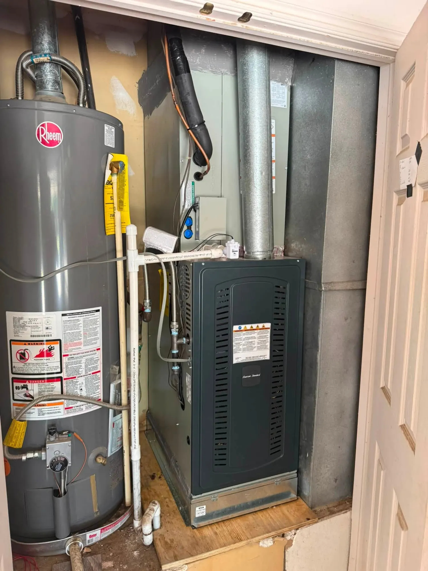Clean furnace installation alongside a water heater in a utility closet