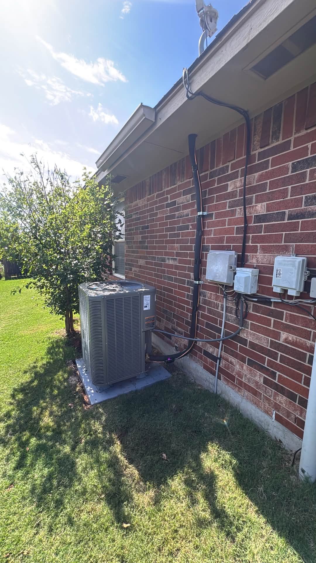 Air conditioning condenser installed beside a Houston brick home